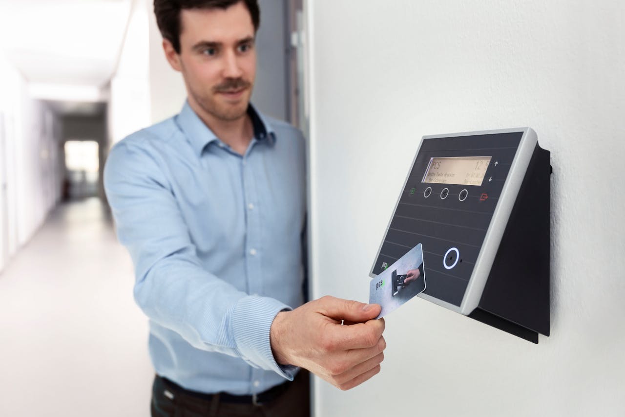 contact-img Professional man using access card on wall reader in office setting.