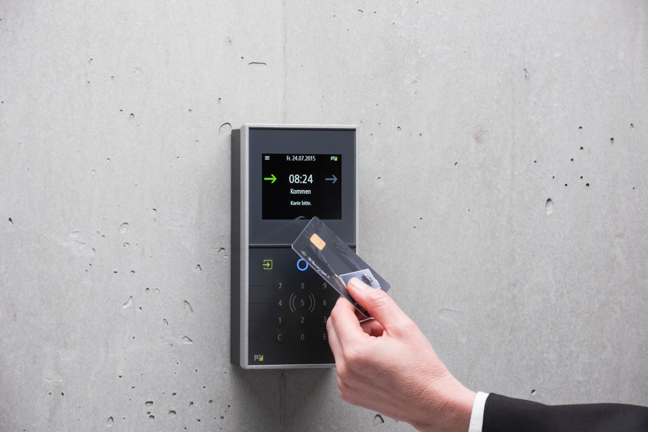 gallery-5 A businessman uses a secure card reader access system against a concrete wall.