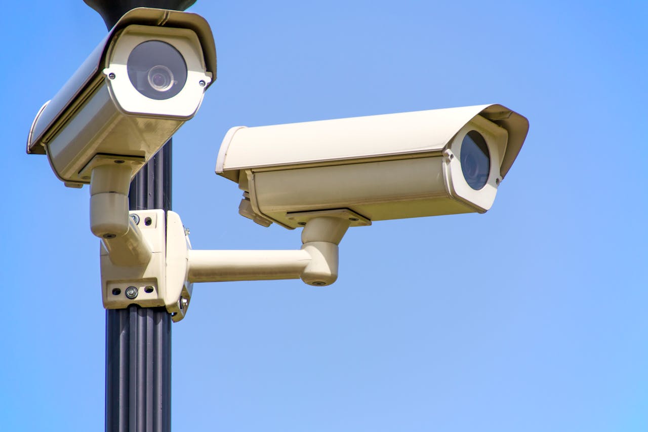 gallery-3 Outdoor security cameras mounted on a pole against a clear blue sky, ensuring vigilant surveillance.